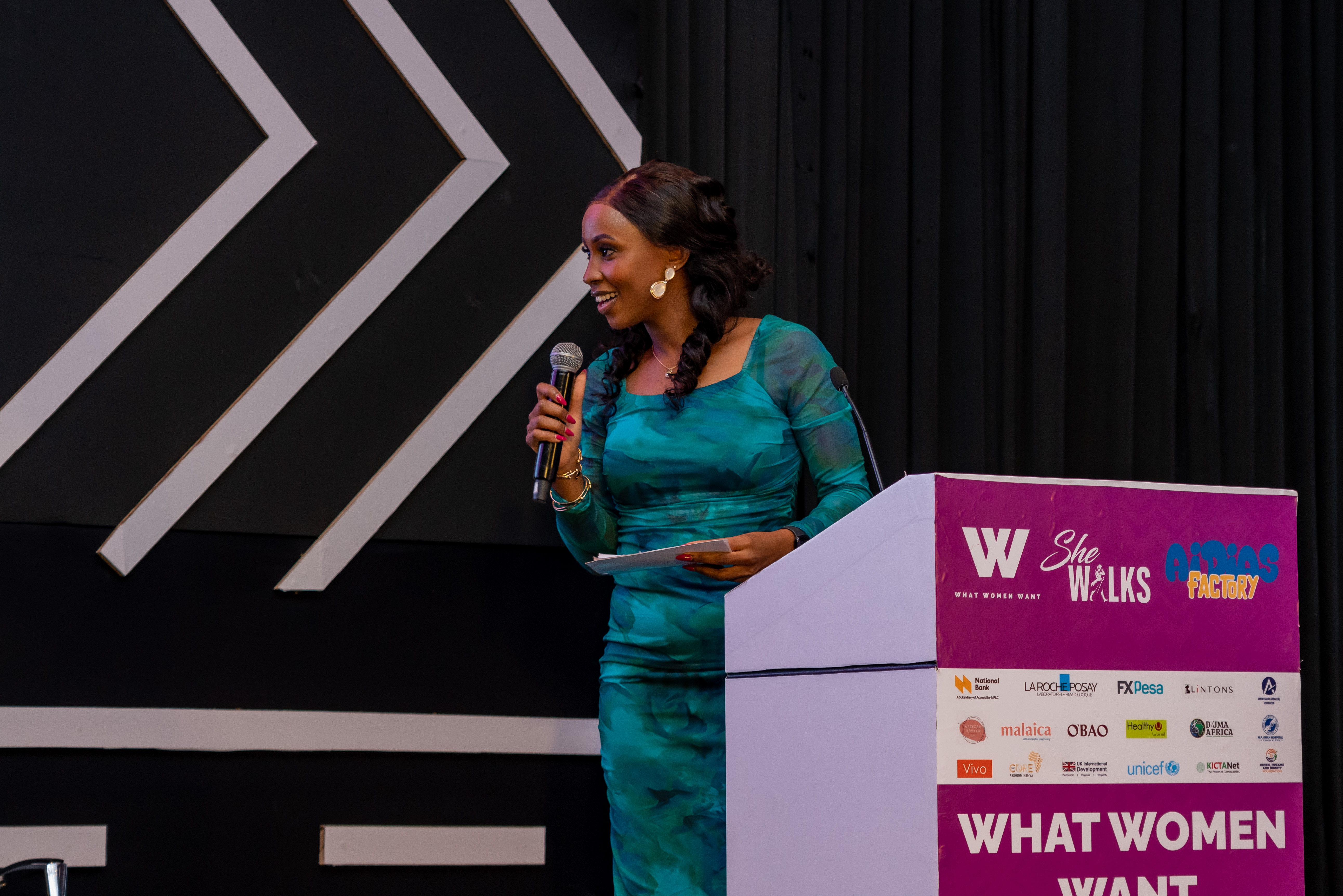 Joy Mido moderating an event on stage